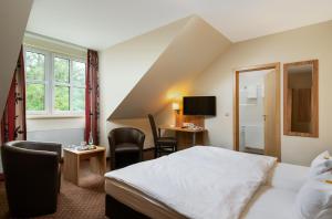 a hotel room with a bed and a desk at ClassicX Landhaus & Hotel - Bed & Breakfast in Gensingen