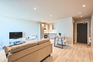 a living room with a couch and a table at Seven Living Bracknell - Serviced Apartments in City Centre - Free Parking in Bracknell
