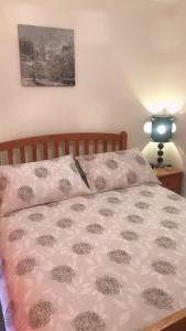 a bed with a pink and white comforter on it at Comfy Home in Aberdeen