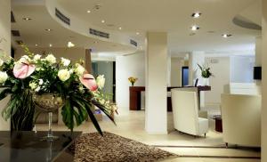 a lobby with a vase of flowers on a table at Rizzi Aquacharme Hotel & Spa in Boario Terme +34 photos