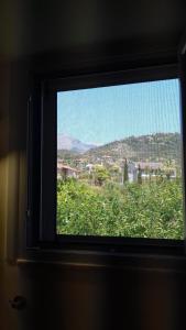 a window in a room with a view of a city at iliolithos rooms in Kardamili
