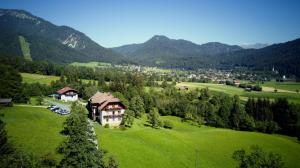 a house on a green field with mountains in the background at Ferienhaus Enzi in Weissbriach