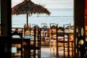 a table with chairs and an umbrella on the beach at Hotel Ristorante La Conchiglia in Cala Gonone