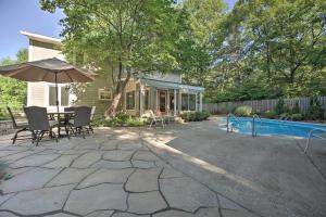 a patio with a table and an umbrella and a pool at Lovely Holland Home with 1 Mile to Lake Michigan! in Holland