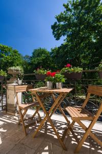 una mesa de madera y sillas en un patio con flores en Vanilla 6 Apartment en Cracovia