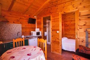 a kitchen and a bedroom in a log cabin at Camping Paxariñas in Portonovo