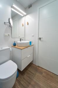 a bathroom with a toilet and a sink and a mirror at El Coso Boutique Lucena in Lucena +46 photos