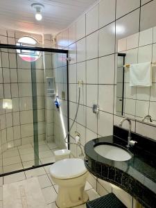 a bathroom with a toilet and a sink and a shower at Principe Hotel in Barreiras