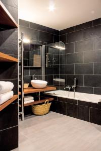 a black bathroom with a sink and a tub at Bastide le Petit Clos - les 2 Gîtes in Perpignan