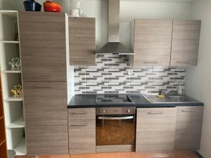 een keuken met houten kasten en een fornuis met oven bij Grand Appartement de 3 pièces in Pierrelaye