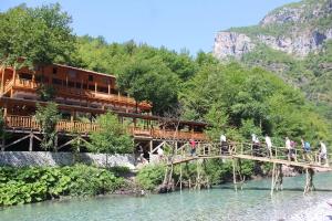 people walking on a bridge over a river at Bee Eco Guest House in Mollʼ e Shoshit