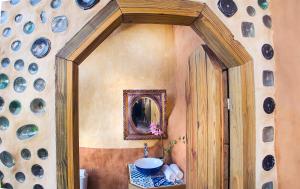 uma casa de banho com um lavatório e um espelho em Caliu Earthship Ecolodge em Colônia do Sacramento