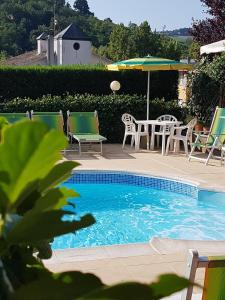 uma piscina com mesa e cadeiras e um guarda-sol em Albergo Hotel Garden Ristorante em Tabiano
