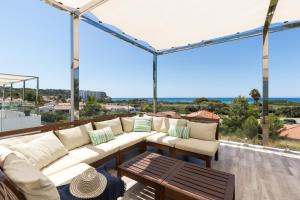 balcón con muebles blancos y vistas al océano en Villa Sunset, en Son Bou