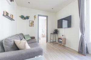 a living room with a couch and a television at Cute Affordable 1-Br Minutes From Cannes Center in Cannes