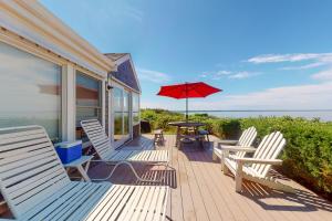 a porch with chairs and a table with an umbrella at 2 Bed 1 Bath Vacation home in Eastham in Eastham