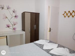 - une chambre avec un lit et une commode ornée de fleurs violettes dans l'établissement Apartamentos beira mar, à Porto de Galinhas