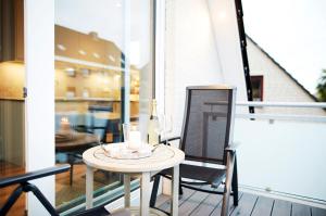 a small table on a balcony with a candle on it at Dat-Meerhus in Büsum