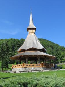 a large building with a tower on top of a field at La Casa Alana in Vişeu de Jos