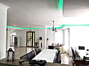 a dining room with a white table and black chairs at La Casa Alana in Vişeu de Jos