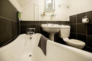 a bathroom with a tub and a sink and a toilet at The Falls Of Dochart Inn in Killin