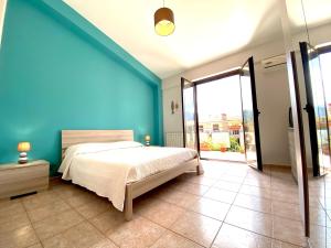 カリーニにあるStunning Sicilian Villaの青い壁のベッドルーム1室(ベッド1台付)