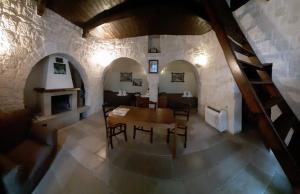 une salle à manger avec une table et une cheminée dans l'établissement Trulli Resort Monte Pasubio, à Alberobello