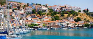 a group of boats docked in a harbor with houses at Hotel Damo in Pythagoreio