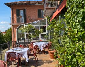 a patio with tables and chairs on a balcony at Felicin - Ristorante Albergo "Dimora Storica" in Monforte dʼAlba
