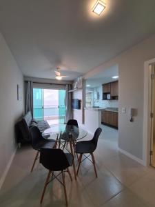 a living room with a glass table and chairs at PORTO AZUL - Praia do Forte - Apart in Cabo Frio