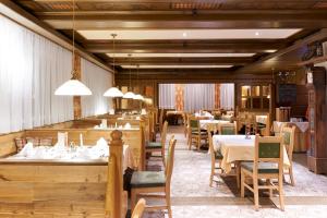 a restaurant with wooden tables and chairs and tablesearcher at Landhotel Post in Heiligenblut