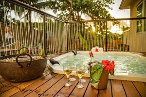 a hot tub with wine glasses and a bottle of wine at Dolphin Hotel in Fernando de Noronha