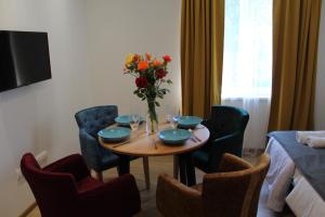 een tafel met stoelen en een vaas met bloemen erop bij Kućica u Šumi Privatni smeštaj Užice in Užice