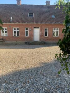 a red brick house with a white door at Anne's Bed & Kitchen, Dalgaard in Horsens