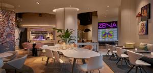 ワシントンにあるHotel Zena Washington DCのテーブルと椅子とバーのあるレストラン