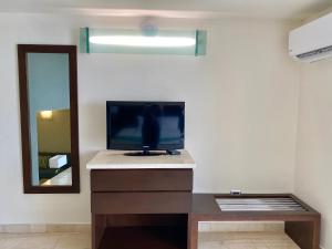 sala de estar con TV y espejo en Seven Crown La Paz Malecon, en La Paz