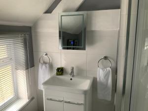 Un baño blanco con lavabo y espejo. en Mackworth House Farm, en Derby 59 fotos más