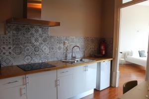 a kitchen with white cabinets and a sink at Casa do Recanto in Porto +37 photos