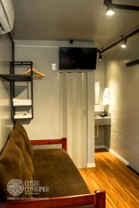une chambre avec un lit et une télévision sur un mur dans l'établissement Pousada Costa Container, à Penha