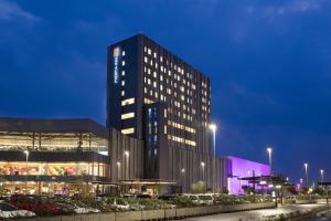 ein hohes Gebäude in der Nacht mit Licht an in der Unterkunft Fiesta Inn Parque Puebla in Puebla