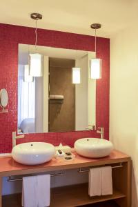 La salle de bains est pourvue de 2 lavabos et d'un grand miroir. dans l'établissement Fiesta Inn Parque Puebla, à Puebla