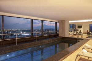 a swimming pool in a building with a view at Fiesta Inn Parque Puebla in Puebla