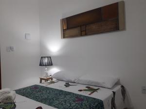 a bedroom with a bed and a table with a lamp at Villa Arte Pousada Morro Branco in Beberibe
