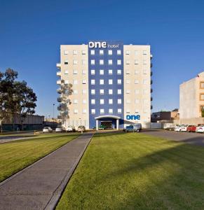 Un grand bâtiment blanc avec le panneau le plus apposé dans l'établissement One San Luis Potosi Glorieta Juarez, à San Luis Potosí