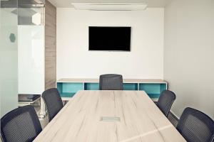 a conference room with a wooden table and chairs at One Tijuana Otay in Tijuana