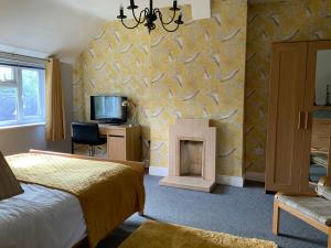 1 dormitorio con 1 cama y chimenea en Mackworth House Farm en Derby