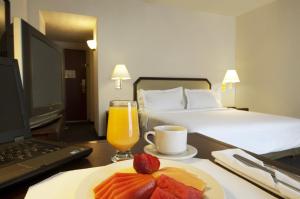 une chambre d'hôtel avec une assiette de fruits et un ordinateur portable dans l'établissement Fiesta Inn Toluca Tollocan, à Toluca