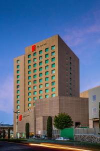 un grand bâtiment avec un panneau en haut dans l'établissement Fiesta Inn Periferico Sur, à Mexico