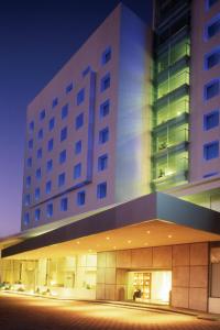 a large building at night with a building at Fiesta Inn Puebla Finsa in Puebla