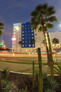 un edificio con una palma di fronte a una strada di One Culiacan Forum a Culiacán